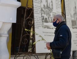 Man in medical mask with willow branches in his hands