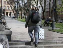 Женщина несет упаковку туалетной бумаги