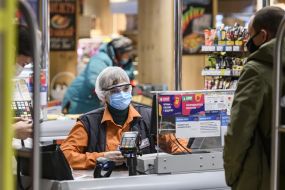 Cashier in medical mask at supermarket