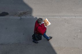 A woman carries a tray of eggs