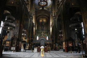 Believer puts a candle on a candlestick