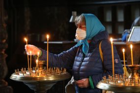 Верующая ставит свечу