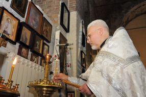 The priest puts candles on a candlestick