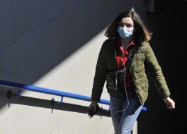 Woman in medical mask emerges from an underground passage