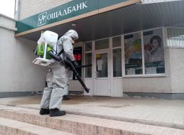 The SES officer conducts a disinfection treatment near the Savings Bank branch