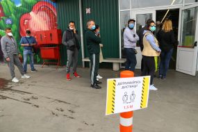People are waiting in line at the entrance to the market
