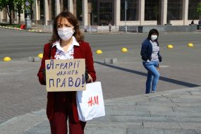 Participant of peaceful protest action "SaveFOP" holding a poster labeled "Agrarians are right!" on Independence Square