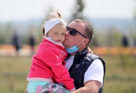Man with girl in his arms at the Dobropark Arboretum