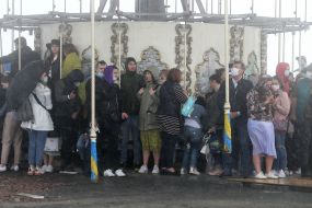 A crowd of people are hiding from the showers in the Park "Dobromir"