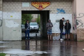 Перехожі ховаються від дощу під накриттям