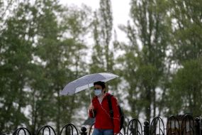 Жінка з парасолькою йде під дощем