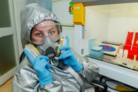 Medical worker in respiratory mask and protective suit