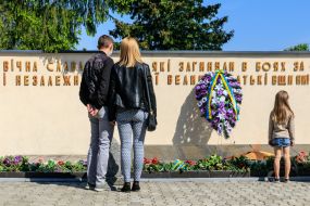 People lay flowers to the Eternal Flame