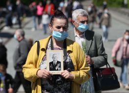 Женщина держит портрет погибшего в годы войны родственника