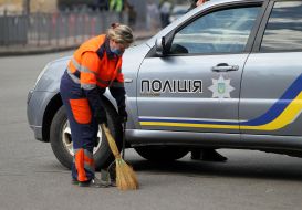 Сотрудница коммунальной службы убирает мусор