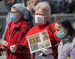 Женщина держит портреты погибших в годы войны родственников