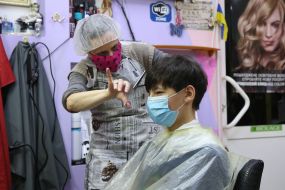 Парикмахер стрижет парня