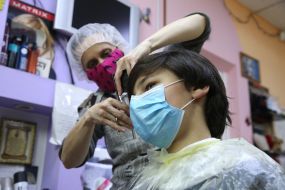 Парикмахер стрижет парня