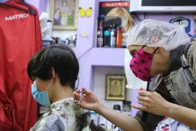 Парикмахер стрижет парня