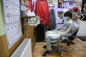 Парикмахер стрижет парня