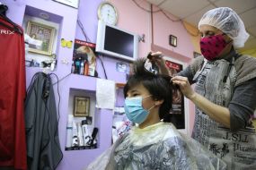 Парикмахер стрижет парня