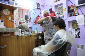 Парикмахер стрижет парня