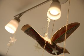 A decorative bird suspended from a chandelier