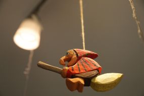 Suspended to the chandelier decorative Baba Yaka on a broom