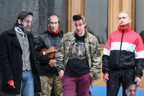 Masked activists with portraits of Andrei Yermak, Vladimir Putin and Vladimir Zelensky