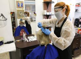 Hairdresser cuts a woman