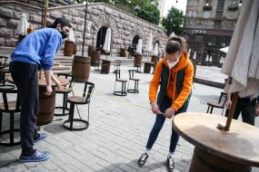 Coffee shop workers measure the distance between tables on the summer playground