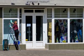 Женщина моет витрины магазина