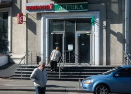 Жінка читає графік роботи аптеки