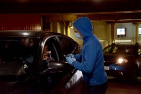 A man in a mask and gloves scans the ticket