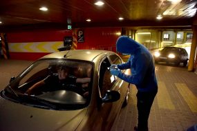 A man in a mask and gloves scans the ticket