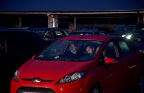 People in cars on the roof of the parking lot