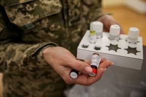 The serviceman is holding reagents for PCR tests
