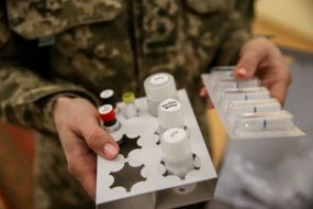 The serviceman is holding reagents for PCR tests