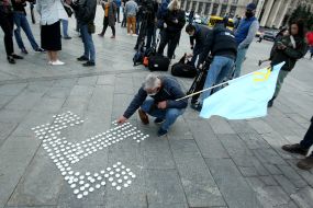The participant of the action lights candles in the form of the emblem of the Crimean Tatars