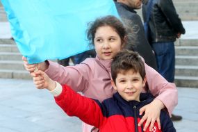 A boy and a girl hold the flag of the Crimean Tatars