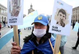 The protester holds portraits of political prisoners