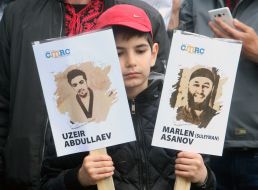 A boy holds portraits of political prisoners