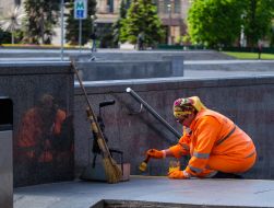 A utility worker paints a yellow line on the stairs of the underpass
