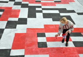 The woman draws an embroidered ornament
