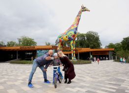 A man, a woman and a boy are photographed on the renovated square in front of the entrance to the Kyiv Zoo