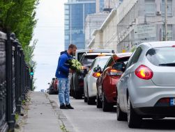 A man carries a large bouquet of lilies of the valley