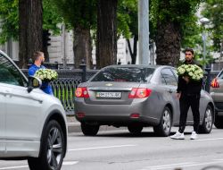 A man carries a large bouquet of lilies of the valley