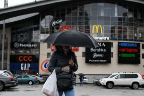 Woman with umbrella at the entrance to the shopping and entertainment center in Kyiv