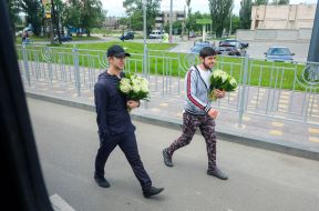 Guys sell bouquets of lilies of the valley on the road