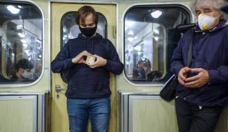 Молодой человек собирает кубик Рубика